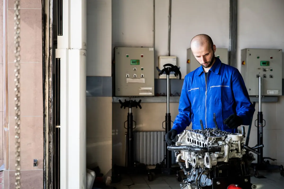 Mechanik pracuje przy bloku silnika na stanowisku