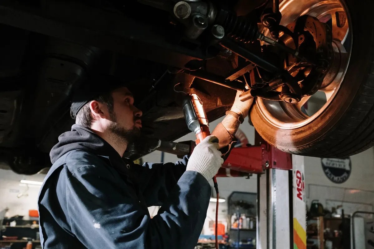 Mechanik oświetla podwozie podczas przeglądu