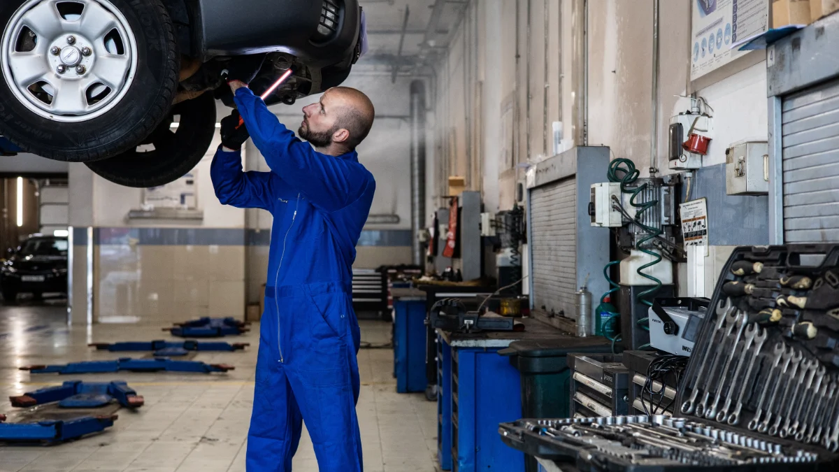 Mechanik pracujący bezpiecznie na uporządkowanym stanowisku warsztatowym
