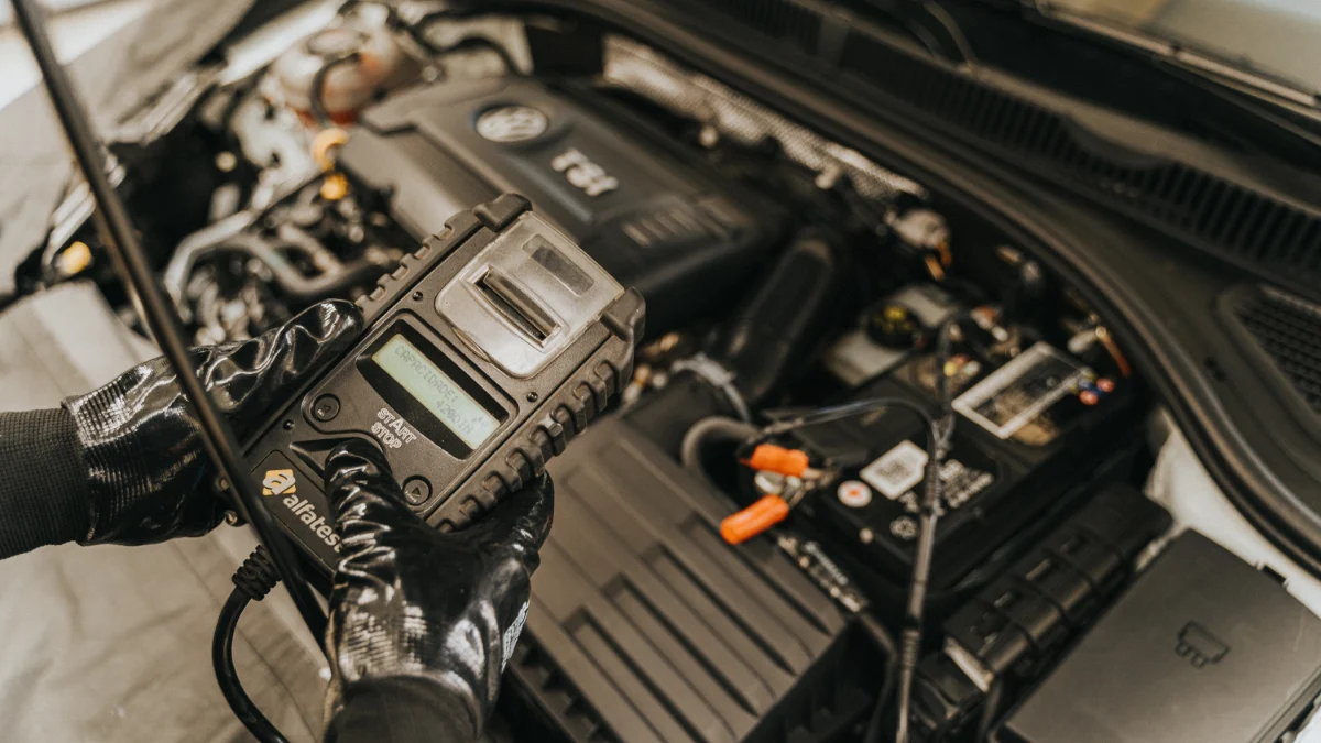 Mechanik używający testera diagnostycznego we wnętrzu samochodu