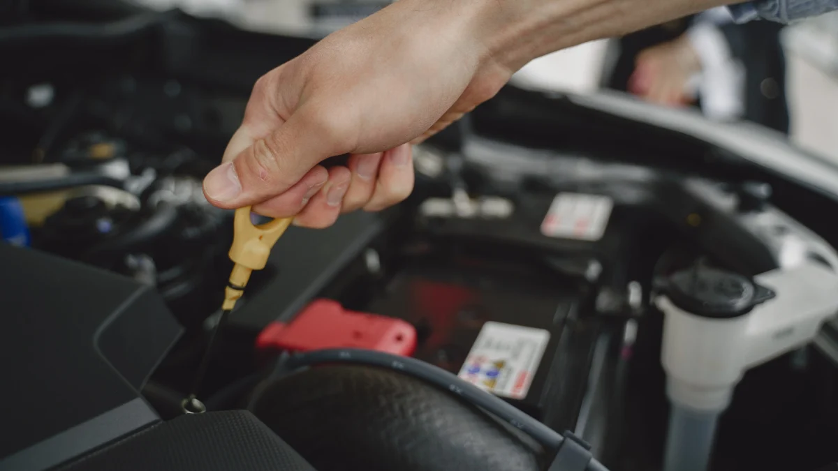 Mechanik diagnozujący silnik benzynowy przy użyciu testera i przyrządów pomiarowych