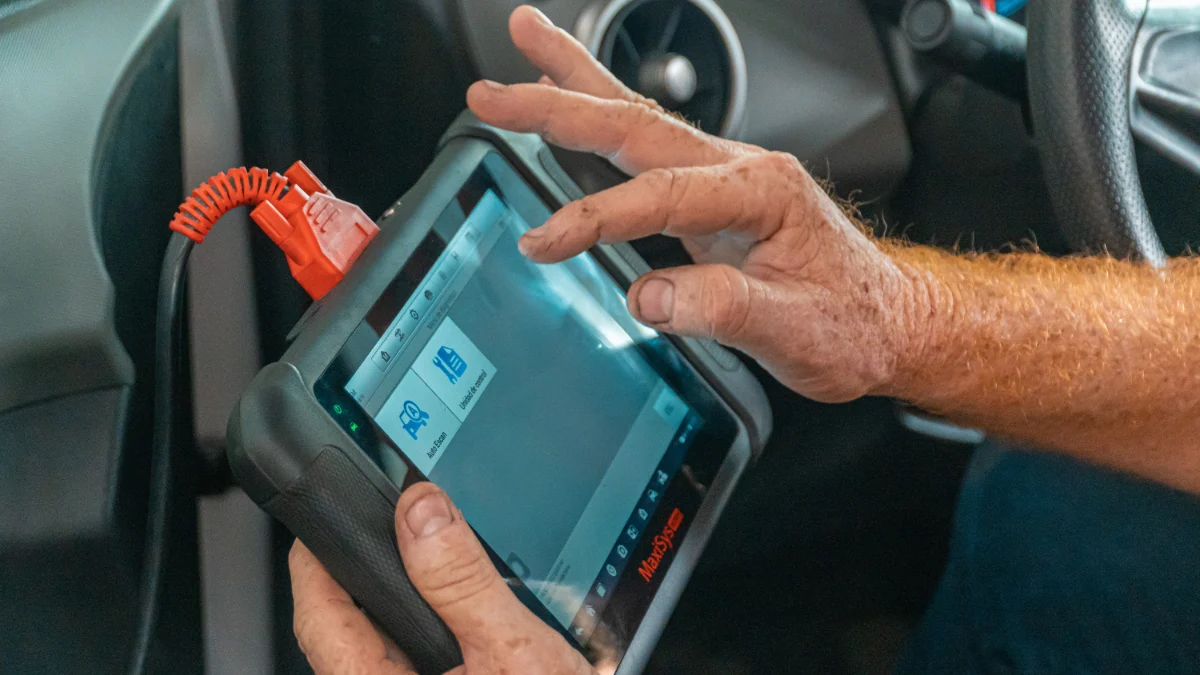 Mechanik korzystający z laptopa podczas diagnostyki samochodu
