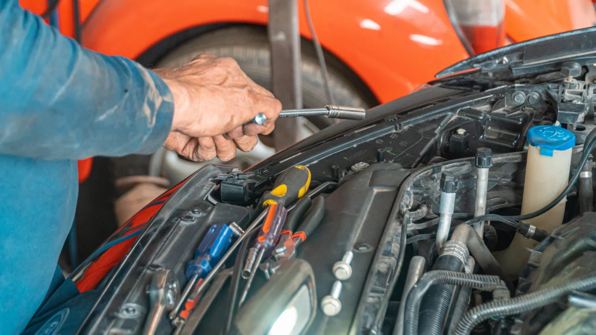 Początkujący mechanik dokumentujący wykonaną pracę przy samochodzie
