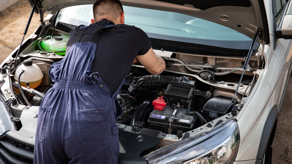 Mechanik naprawiający silnik samochodu w trakcie pracy