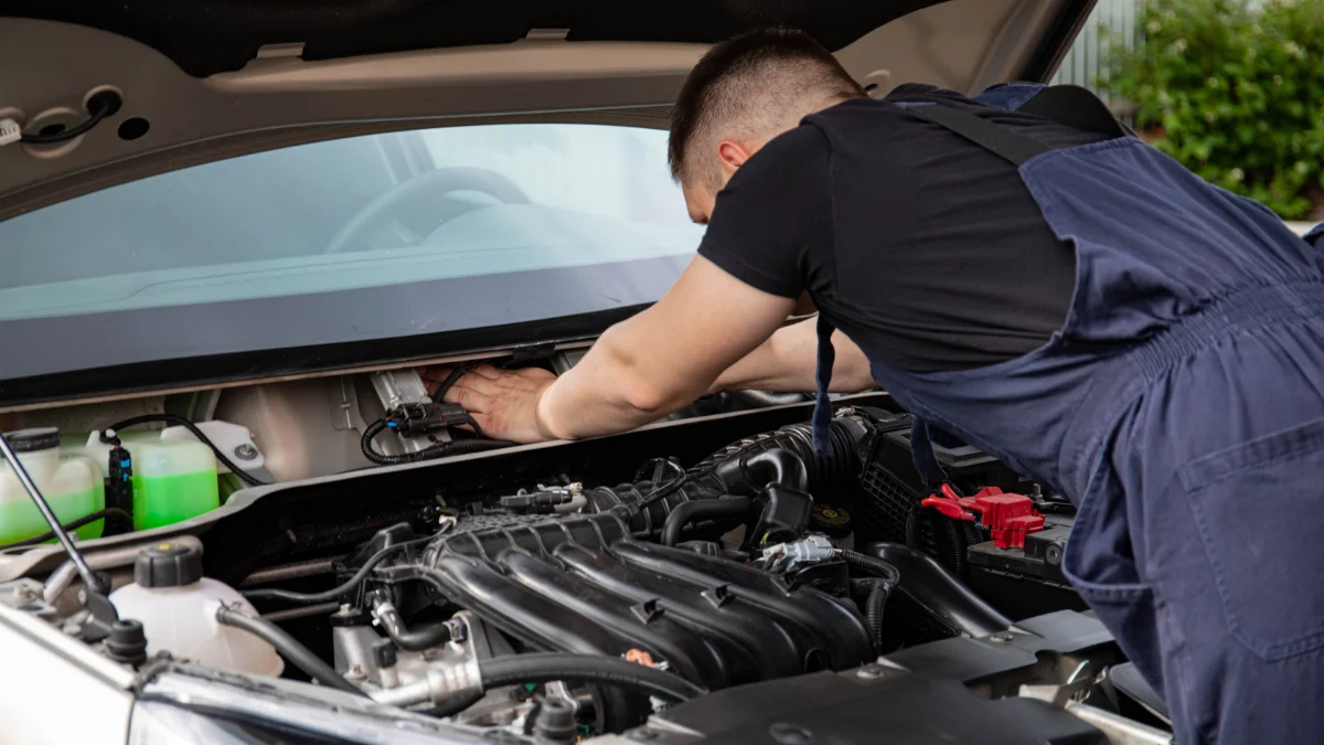 Mechanik pracujący przy samochodzie w nowoczesnym serwisie
