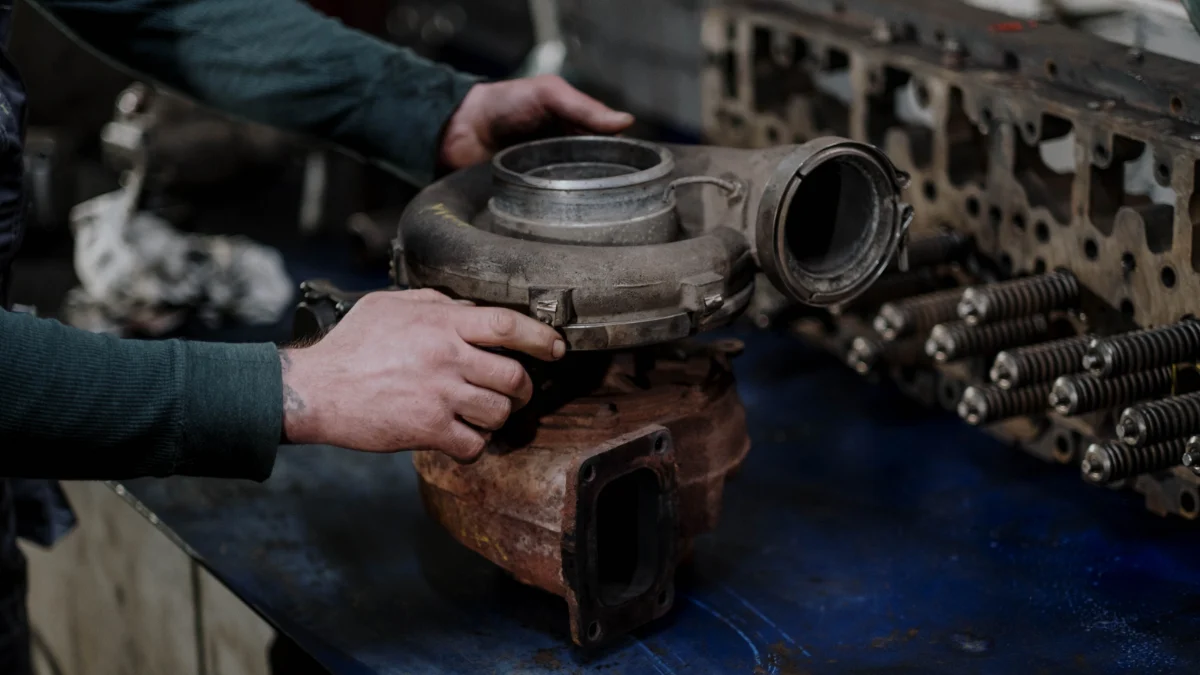 Mechanik sprawdzający przewody dolotowe i turbosprężarkę w komorze silnika
