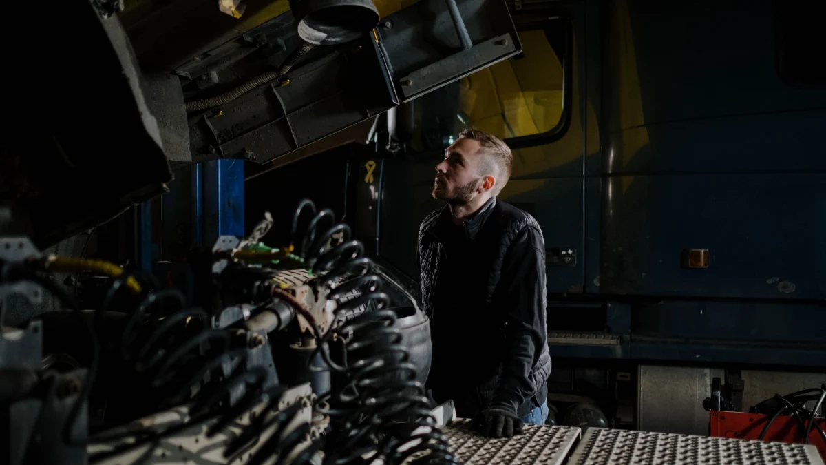 Mechanik pojazdów ciężarowych kontrolujący przewody i elementy układu pneumatycznego